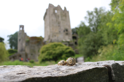 thumbnail view of Bearkat Pride - Brittney Boyd - Ireland - Summer 2019 - Rings at Blarney Castle - Male and Female rings displayed on a rock bench with Blarney castle in the background