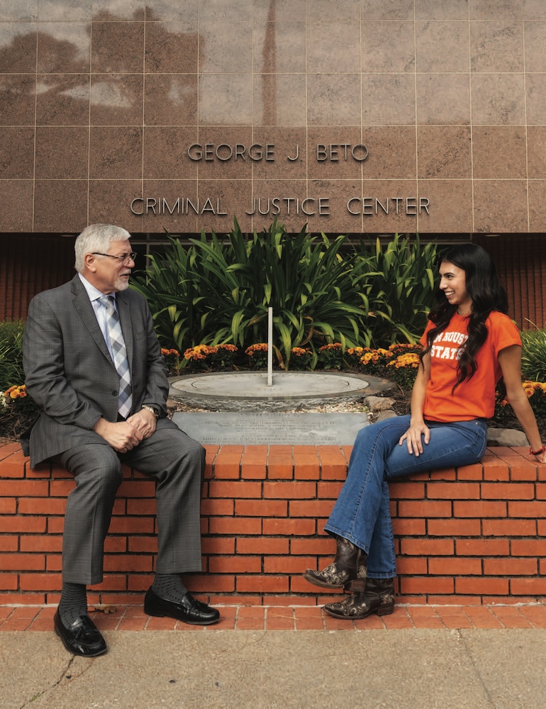 Dean Phillip Lyons (left) chats with a student in front of the Beto Criminal Justice Center.